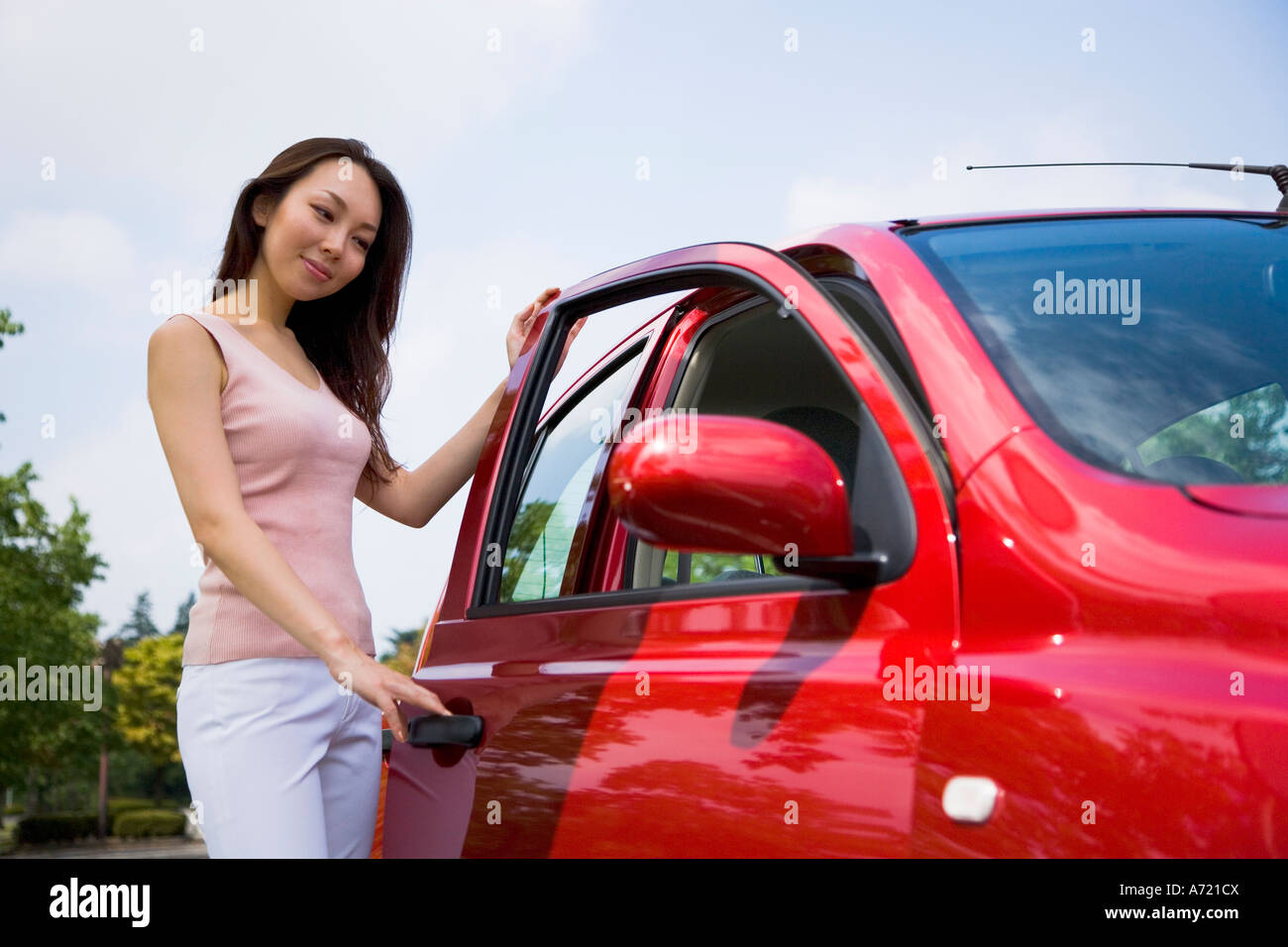 Young woman opening car door Stock Photo - Alamy