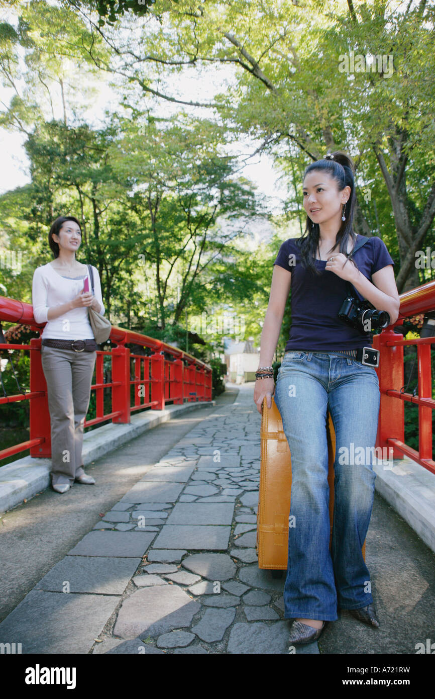 Two young women standing on bridge Stock Photo - Alamy