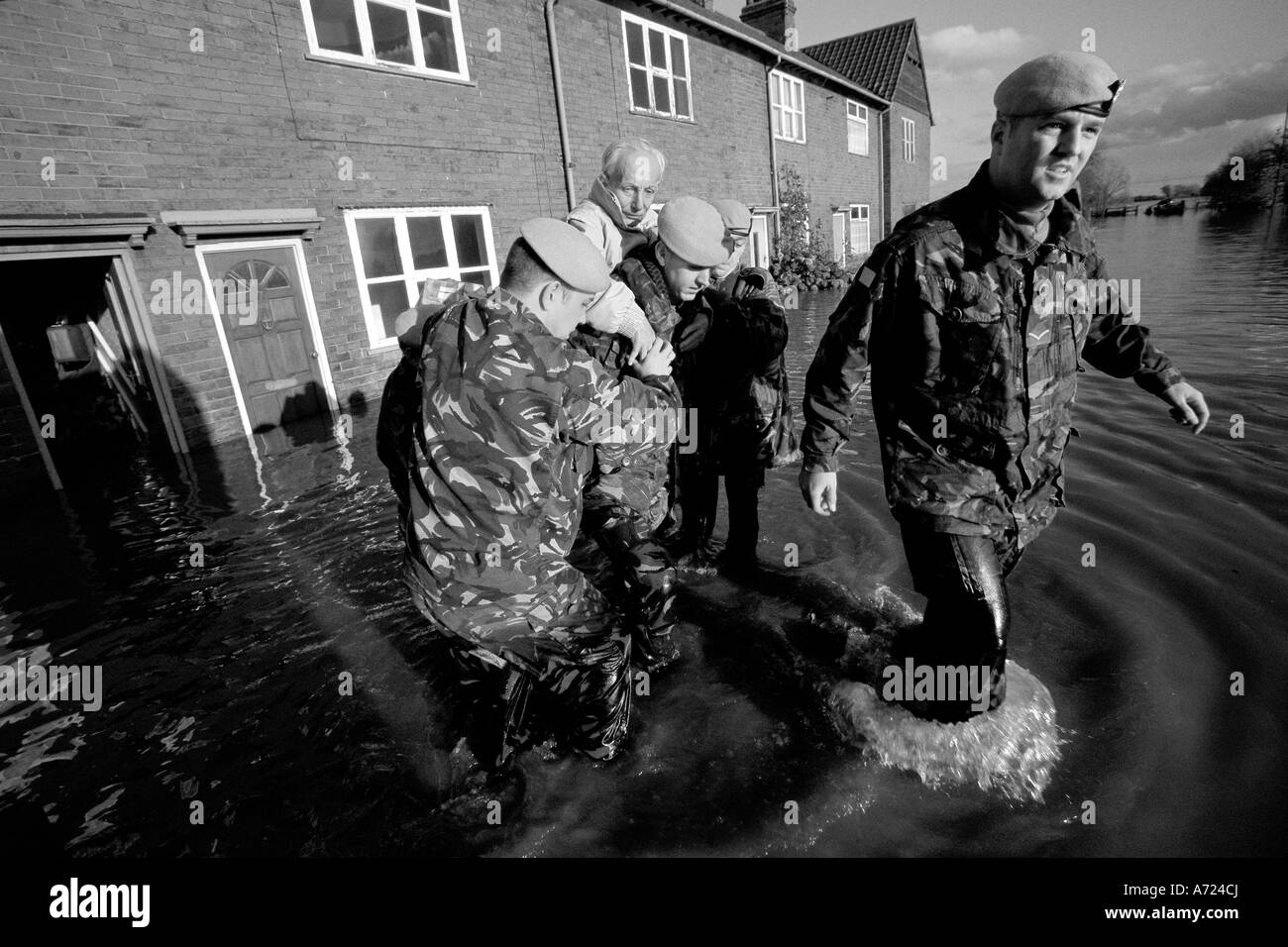 Soldiers rescue an elderly man from floodwaters Stock Photo