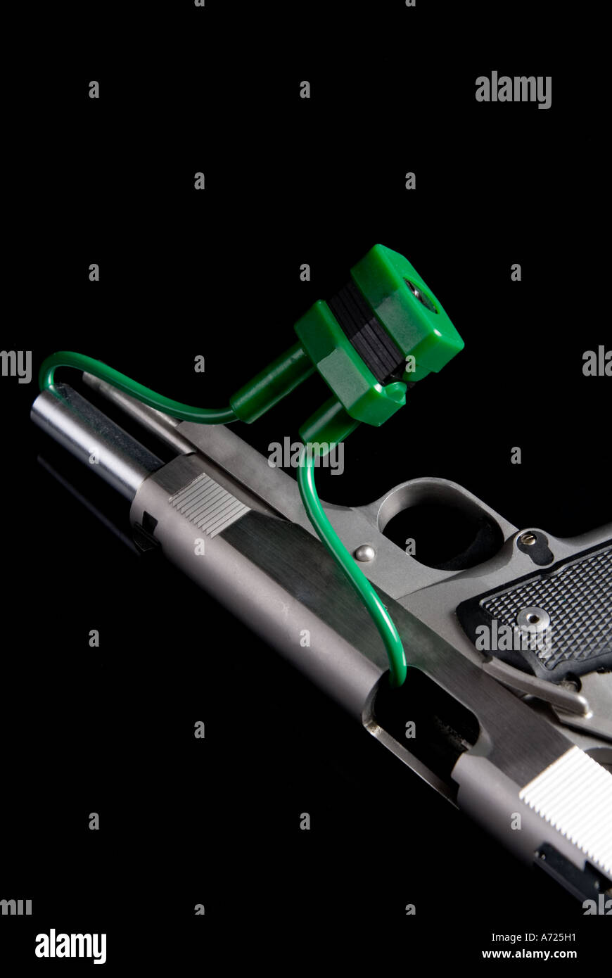 Handgun with safety lock and cable in the breech and barrel Stock Photo