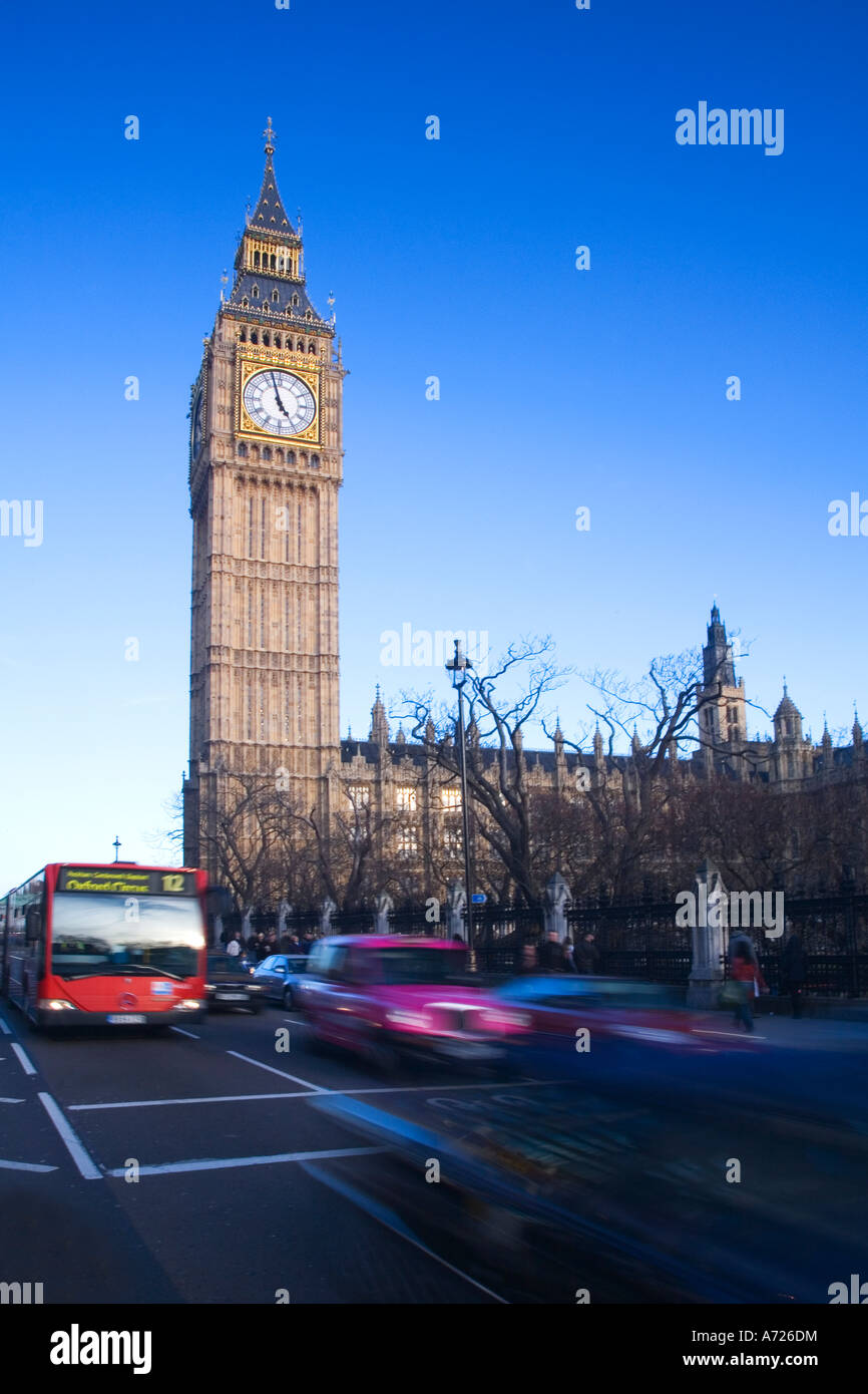 Big Ben clock clocktower red bus and taxi Parliament Square in evening sun sunshine in spring winter London England GB UK Stock Photo