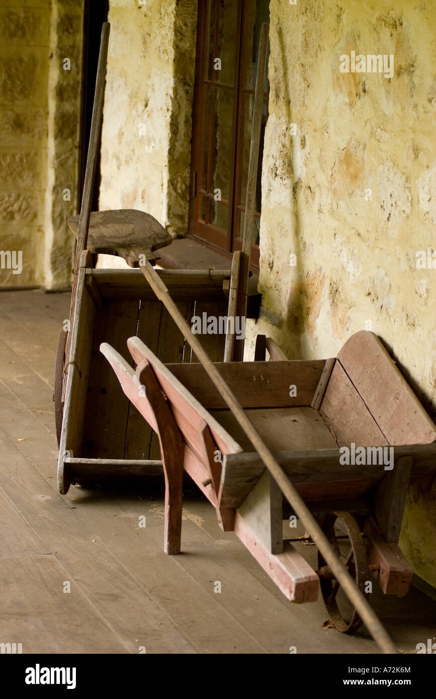 Porch Of A Country Cottage With Antique Wheelbarrow And Implements
