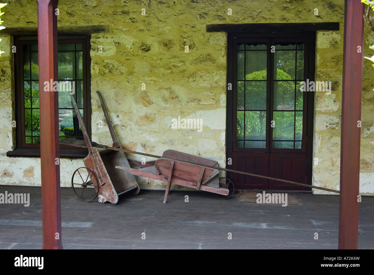 Porch Of A Country Cottage With Antique Wheelbarrow And Implements