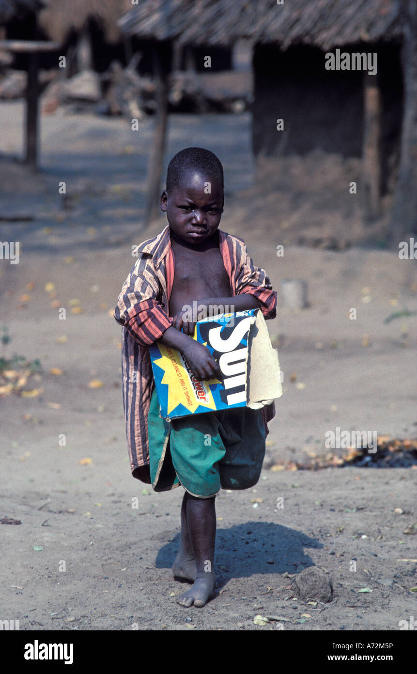 African refugee child in Zimbabwe refugee camp uses an empty soapbox for a toy Stock Photo