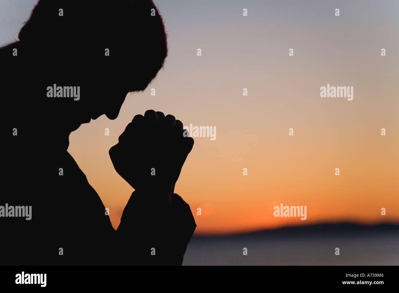 Silhouette of a man praying Stock Photo - Alamy