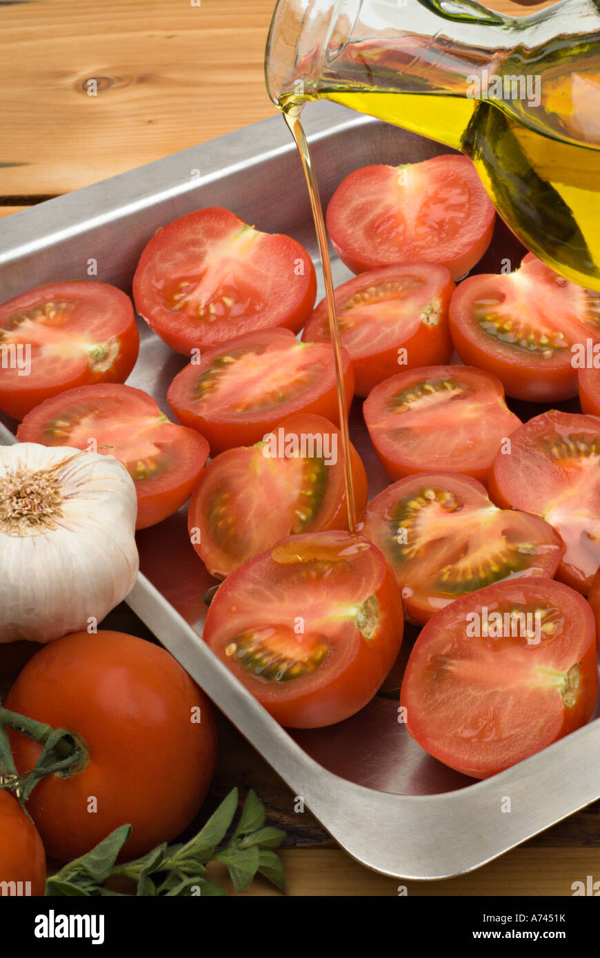 Tomatoes with olive oil pouring over baked tomatoes Stock Photo