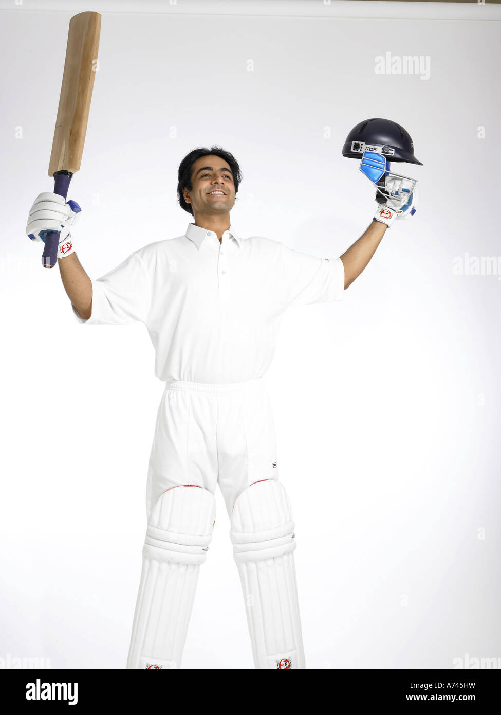 Indian batsman raising bat and helmet celebrating good score in cricket