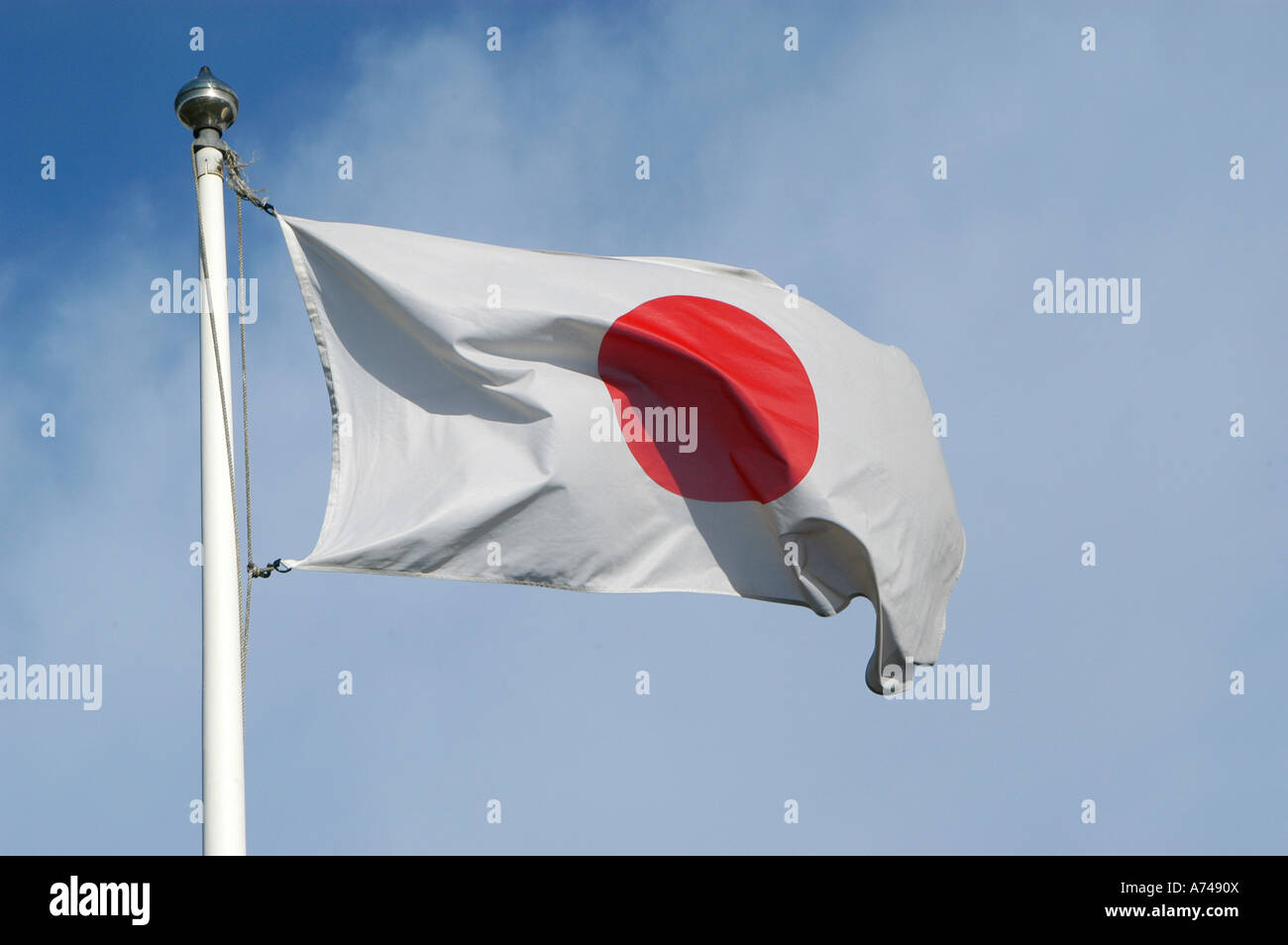 Japanese flag fluttering in the wind against a blue sky Stock Photo