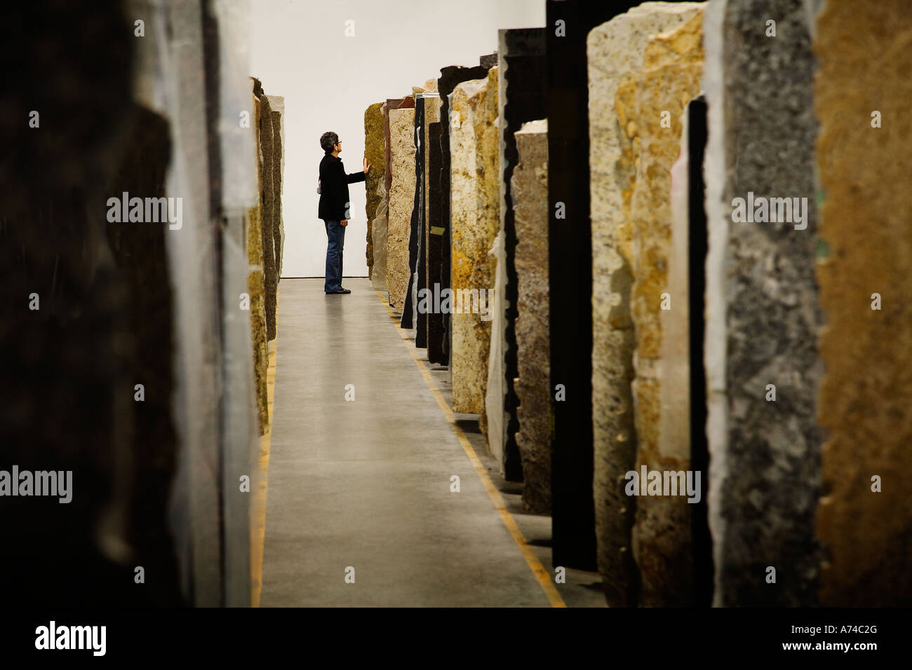 A woman attempts to make a decision on the color of granite she wants from many options Stock Photo