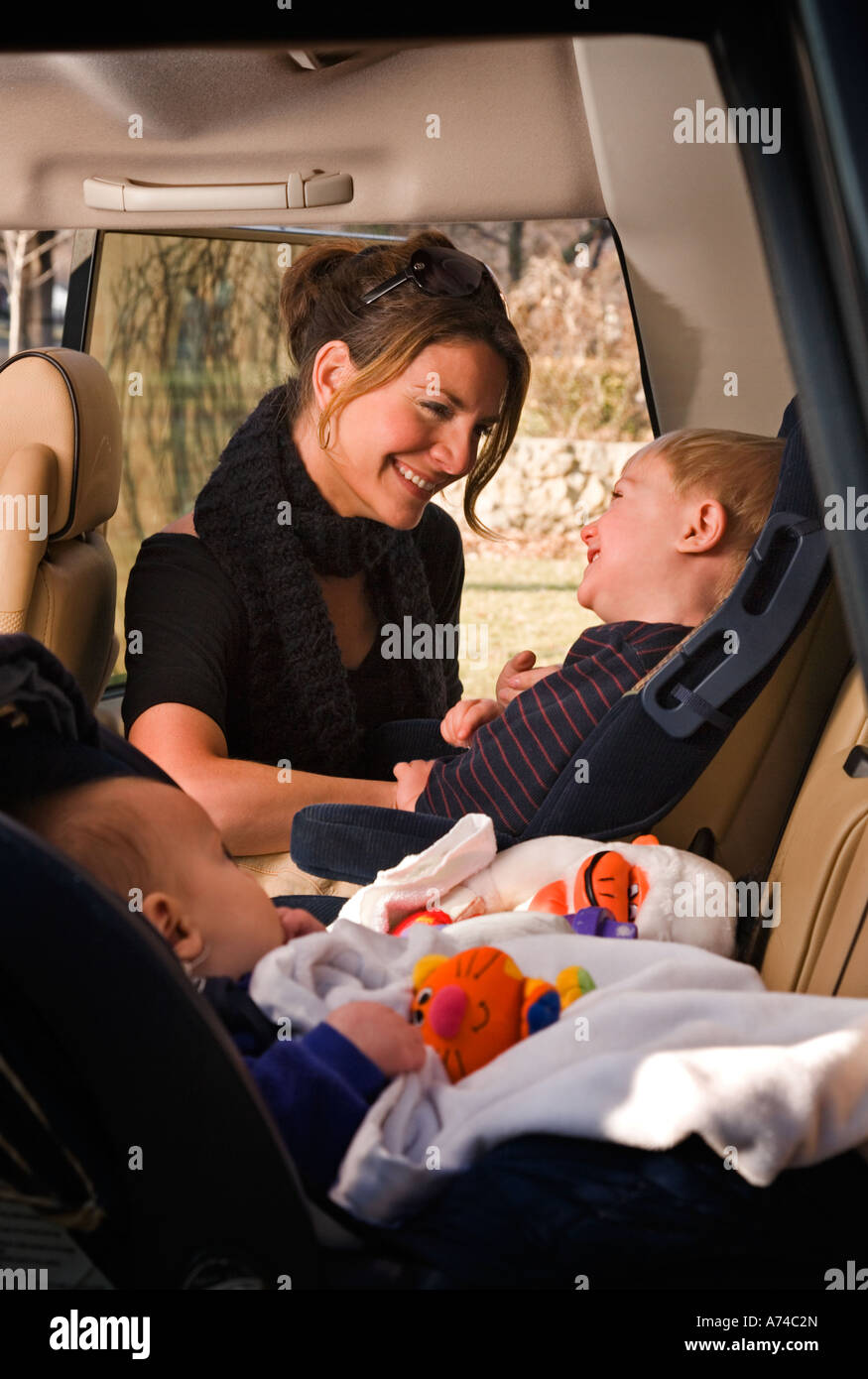 Mother and son have fun while strapping into a car seat Stock Photo Alamy