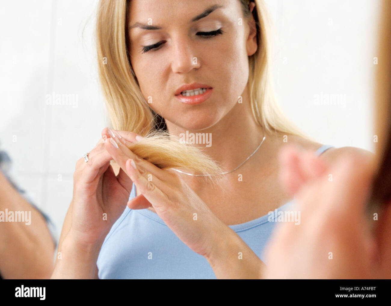 Woman checking hair Stock Photo - Alamy