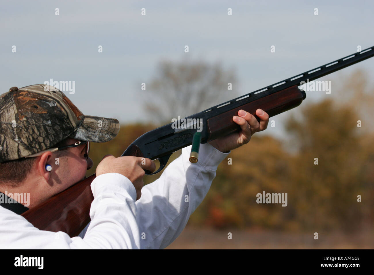 Man shooting a shotgun at clay targets. Stock Photo