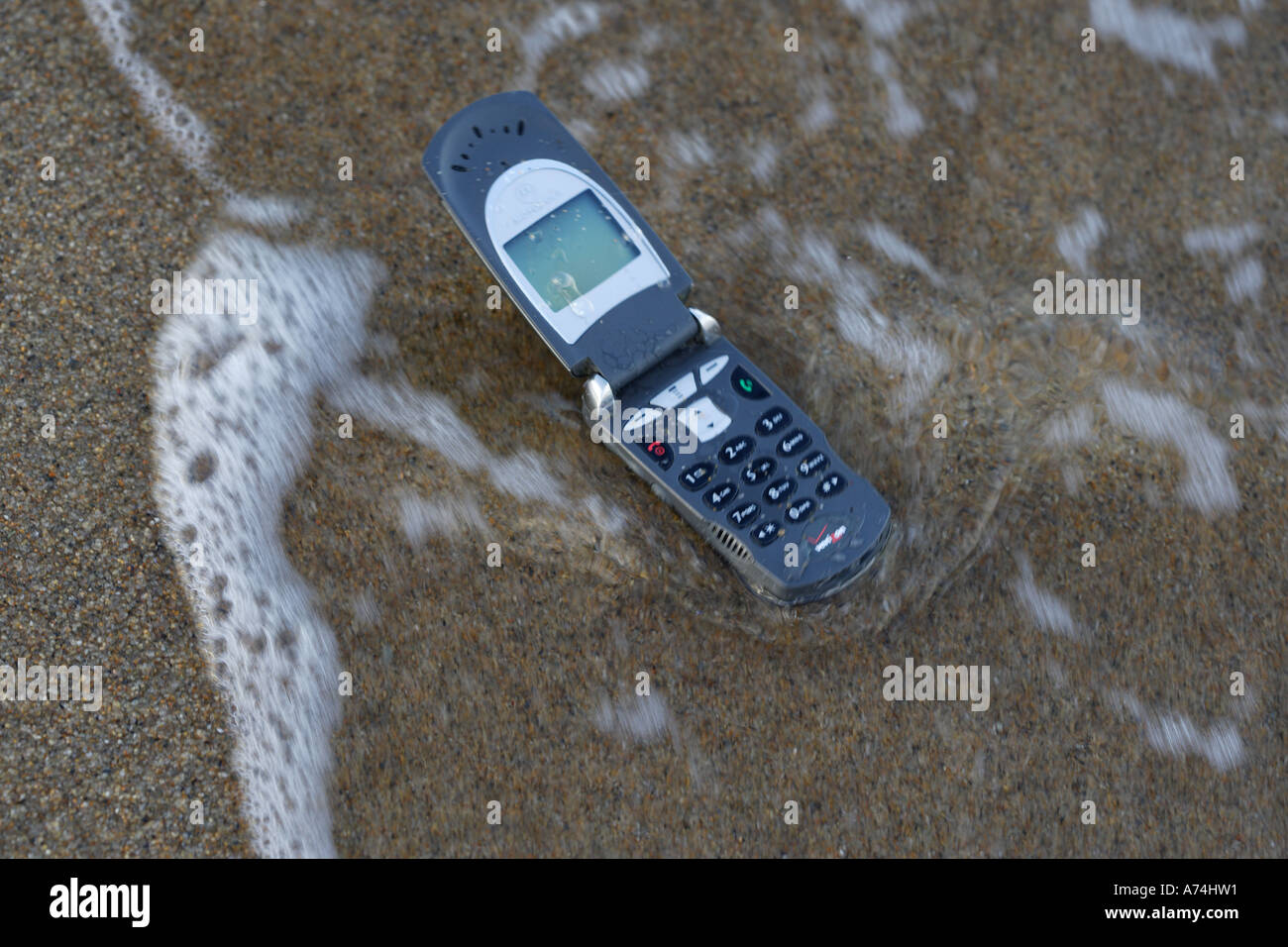 Cell phone washing up on beach Stock Photo