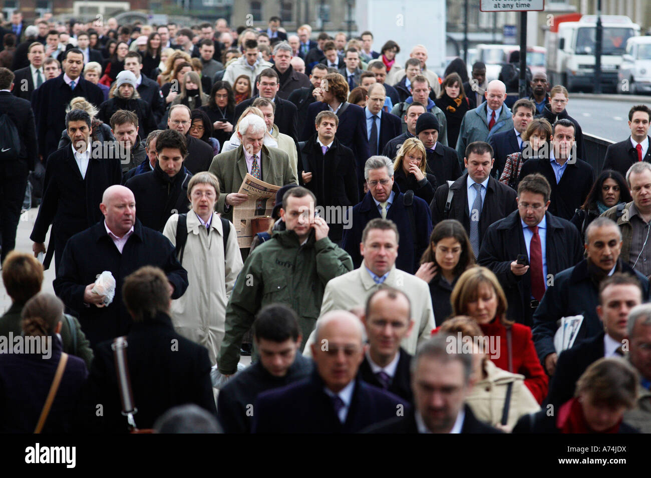Office workers on their way to work in The City of London  crossing London Bridge Stock Photo