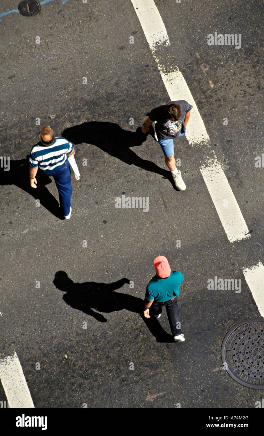 Overhead view of people walking across road between white lines worn ...