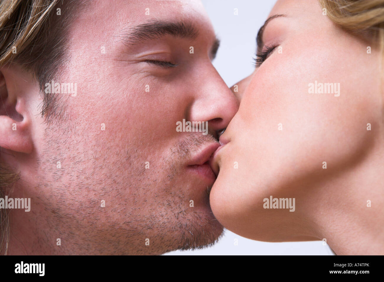 Close-up of a couple locked in a passionate wet kiss, lips pressed intensely