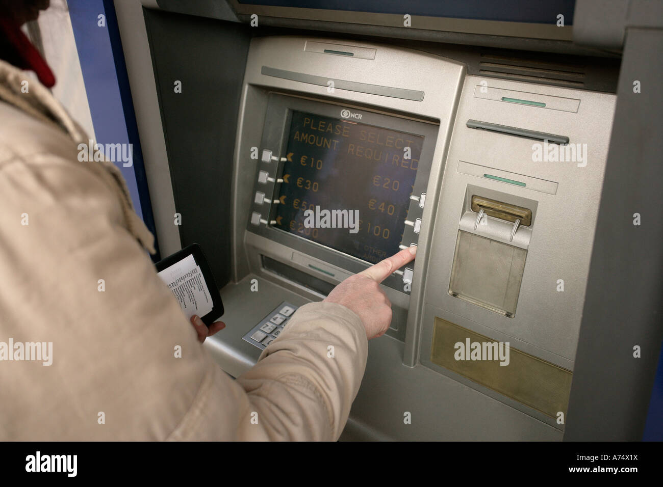 person using cash dispenser Stock Photo