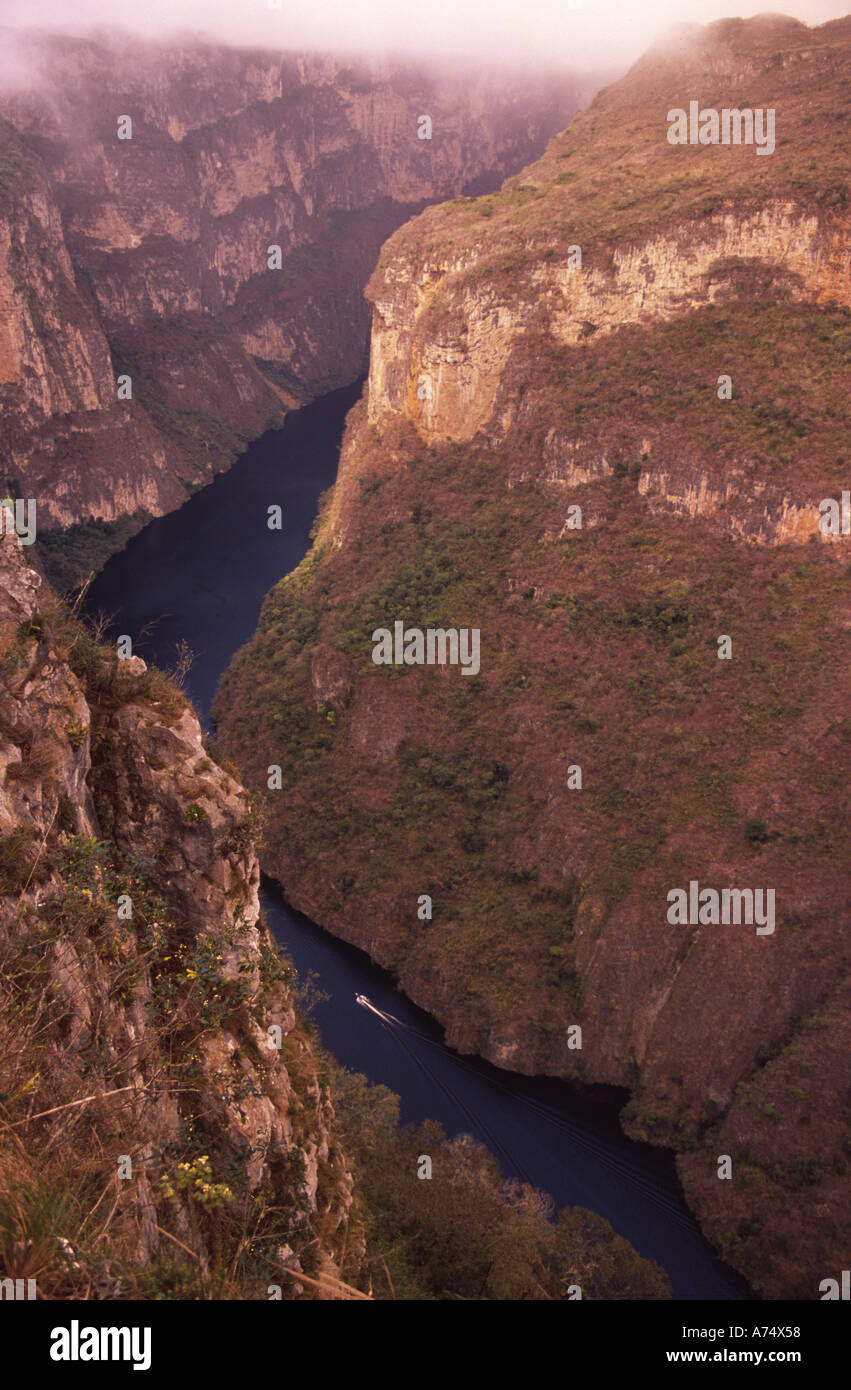 Mexico, Chiapas, Sumidero Canyon National Park. Boat on Grijalva R. 4000ft below canyon walls Stock Photo