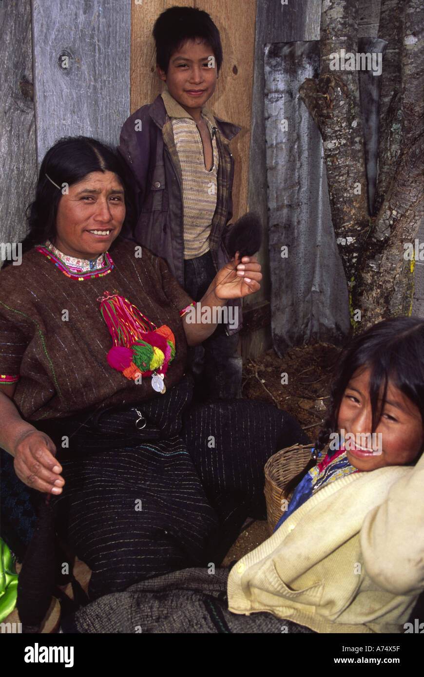 Mexico, Chiapas, San Cristobal, Candelaria Village. Tzotzil Indian children pose & mother spins wool Stock Photo