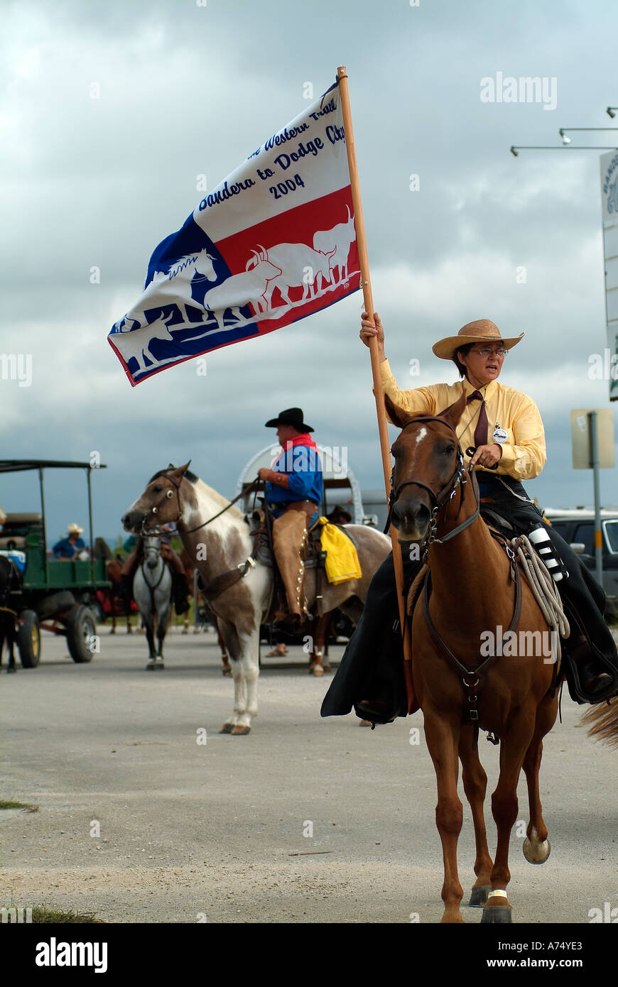 Woman with a flag riding a horse in Bandera Texas Stock Photo
