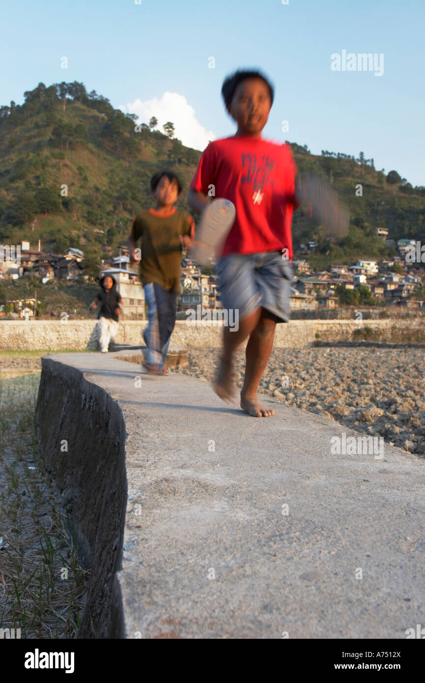 Children Running On Path Through Rice Fields Stock Photo