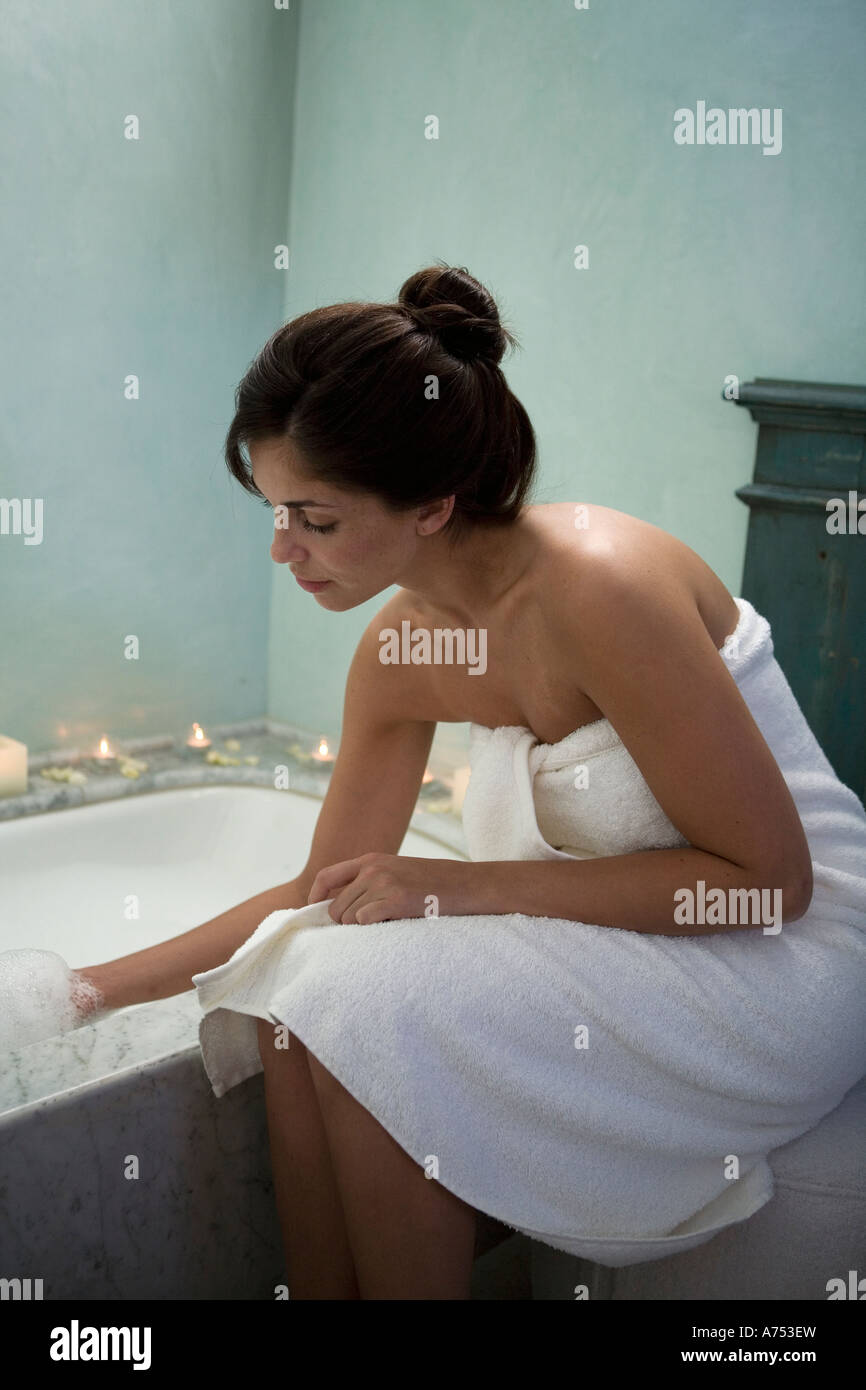 Woman testing bathwater Stock Photo