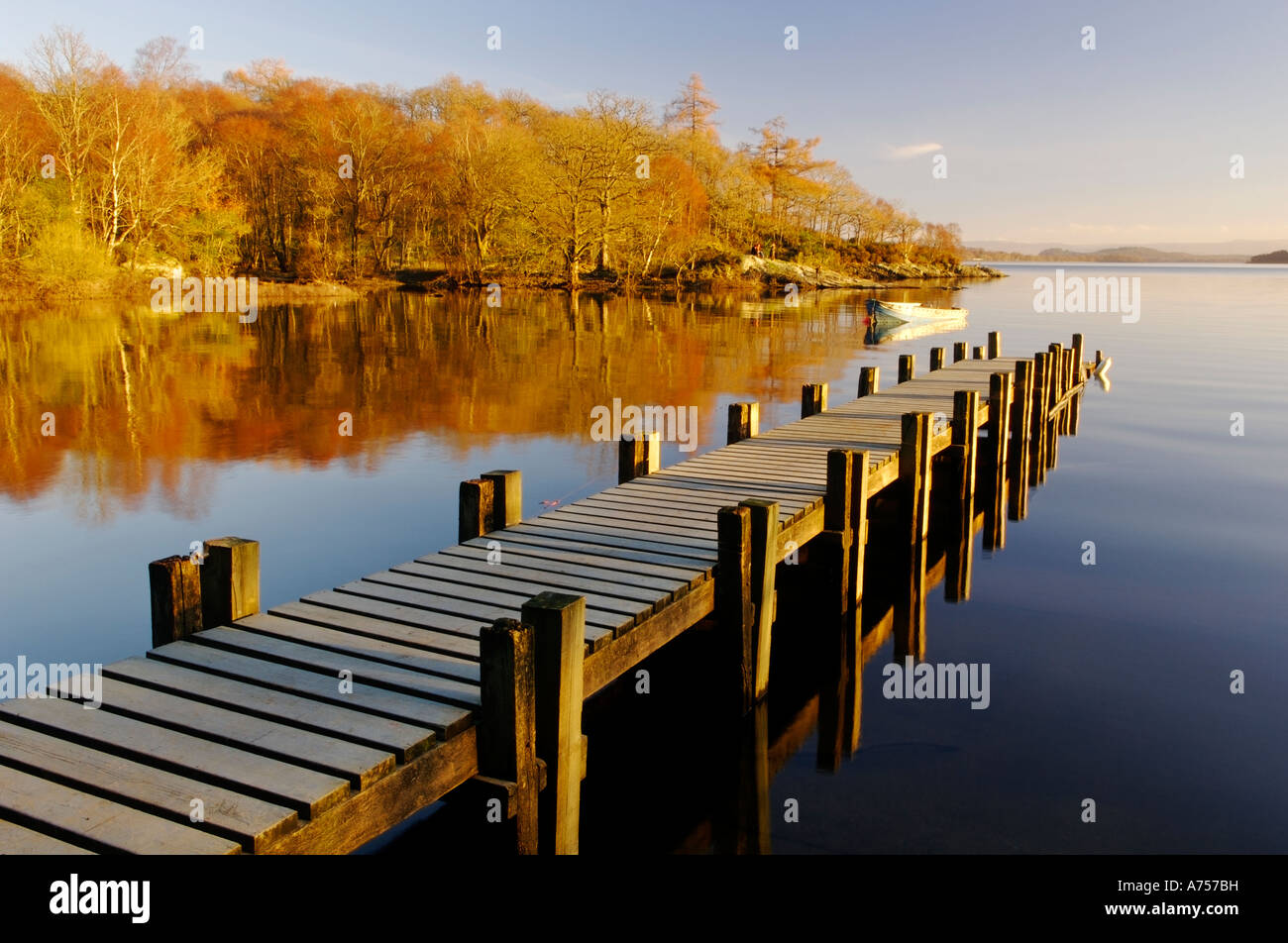 Late light on wooden jetty and rowing boat Loch Lomond Scotland UK