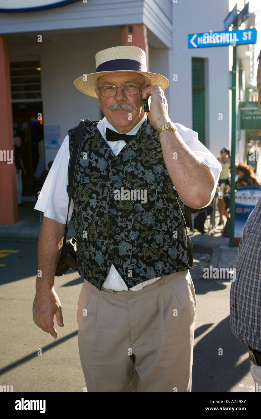 Man in 1930s clothes using mobile phone Art Deco weekend Napier North Island New Zealand Stock Photo
