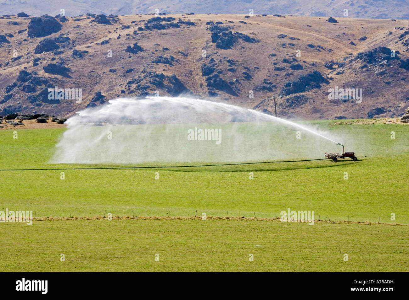 High pressure water irrigation of pasture near Cromwell South Island New Zealand Stock Photo