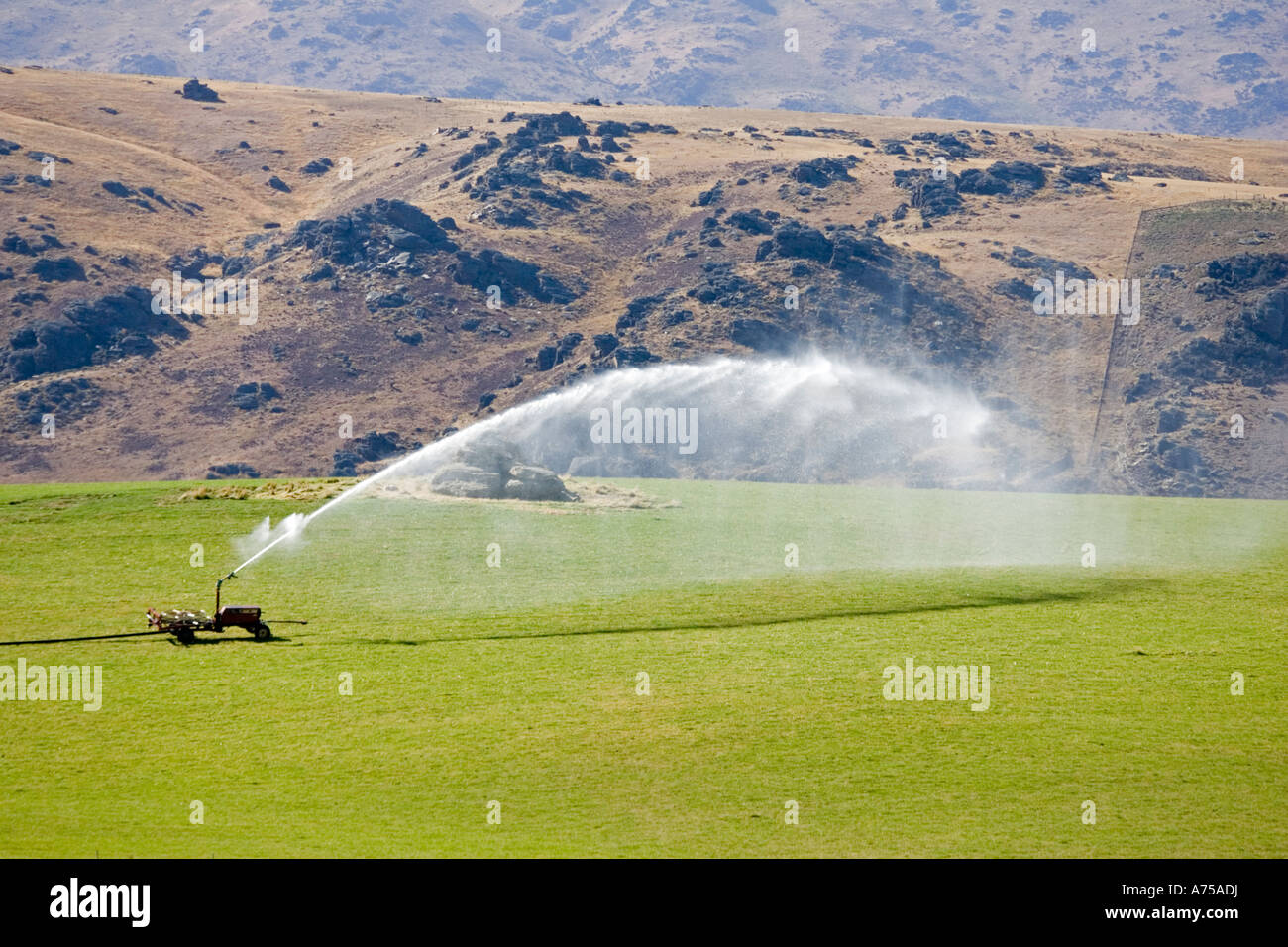 High pressure water irrigation of pasture near Cromwell South Island New Zealand Stock Photo