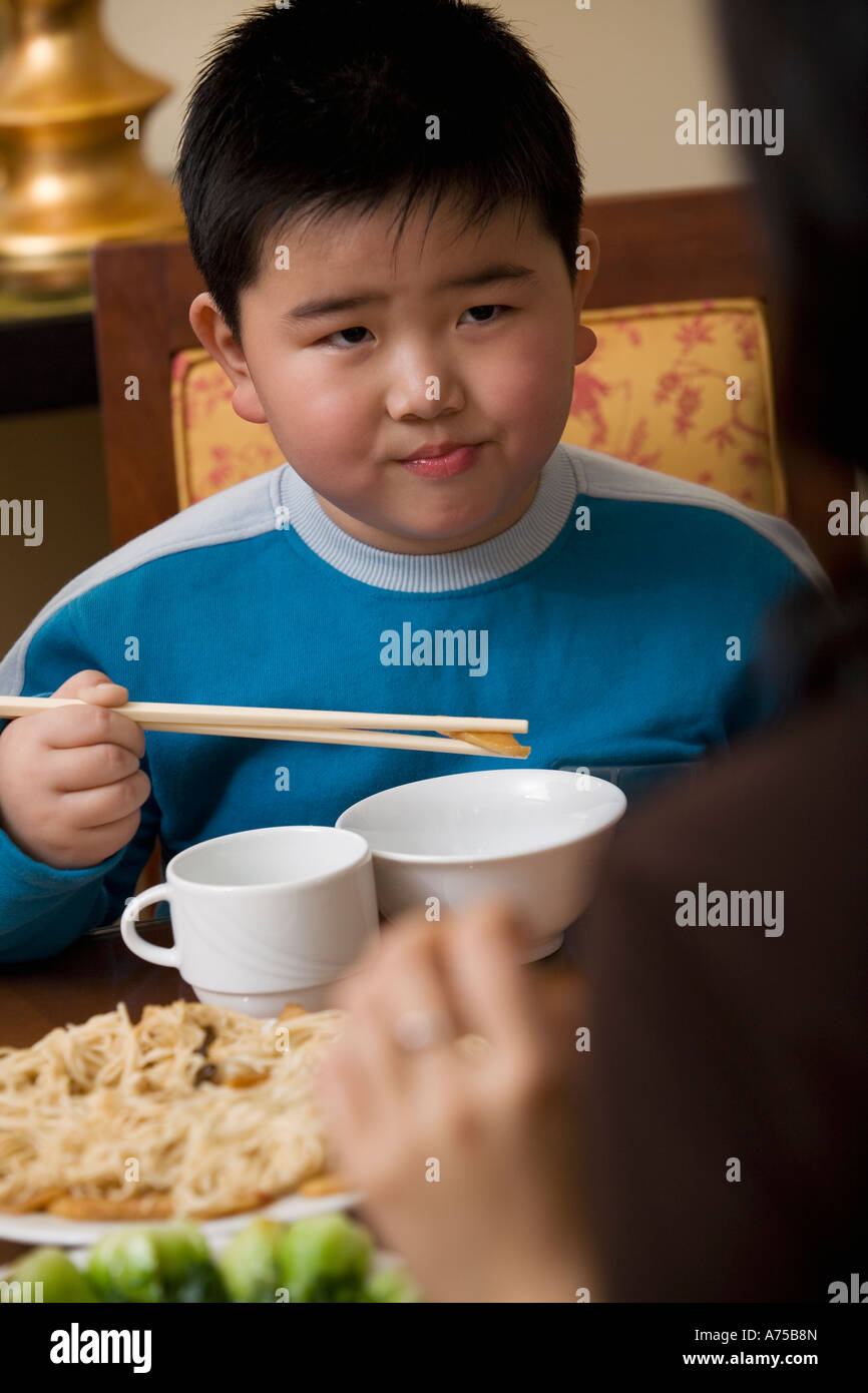Young boy eating with chopsticks Stock Photo Alamy
