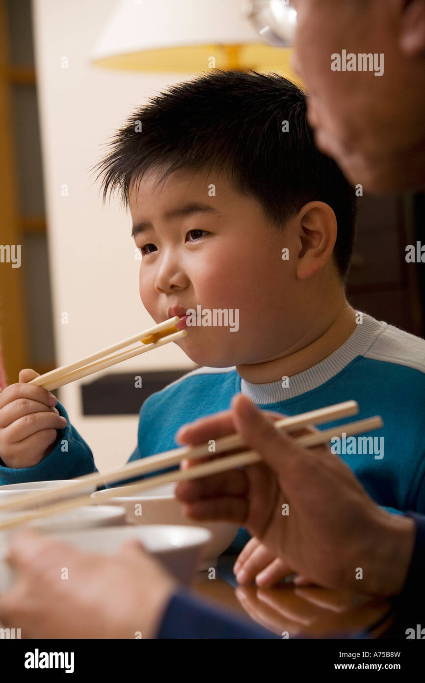 Young boy eating with chopsticks Stock Photo Alamy