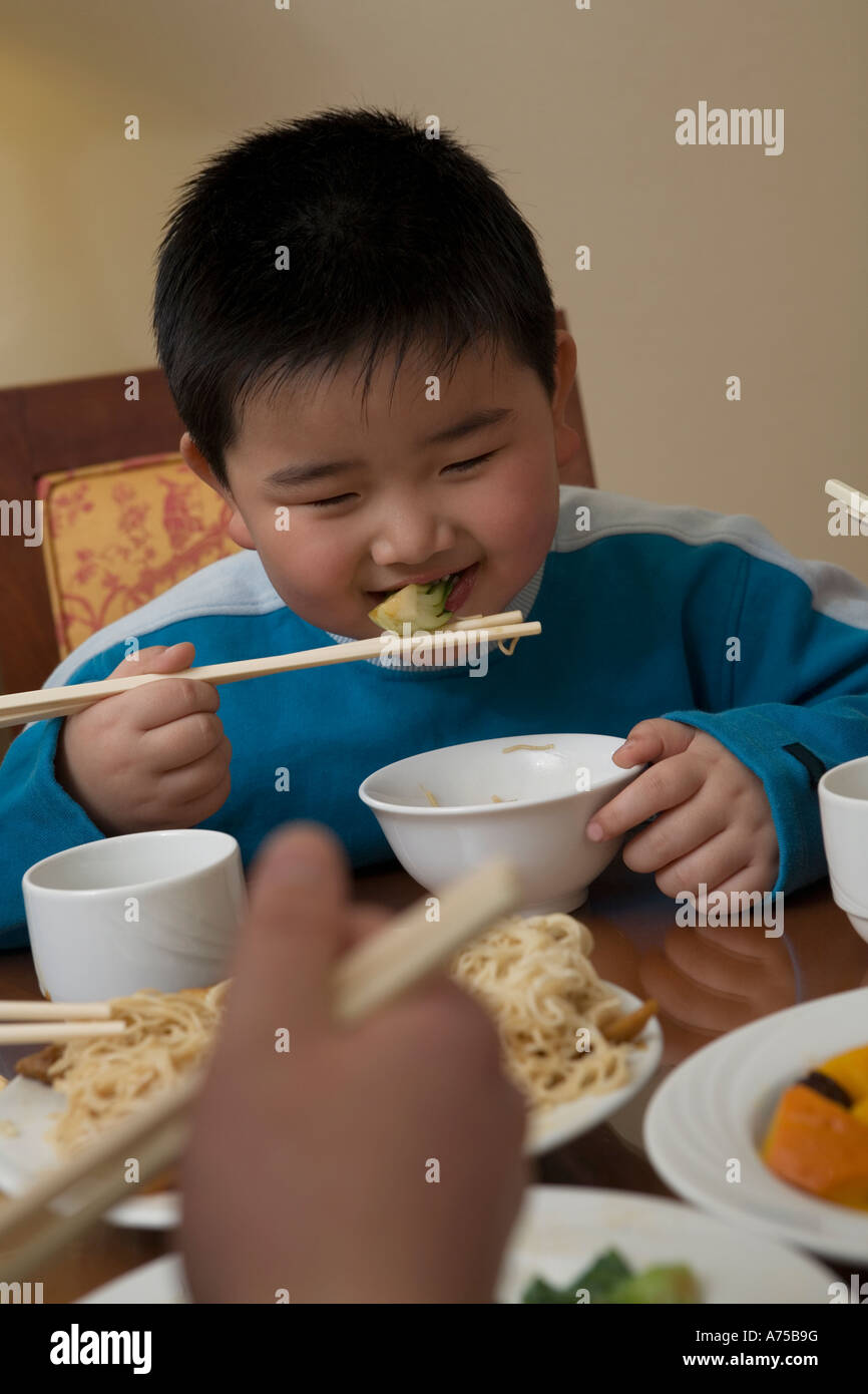 Young boy eating with chopsticks Stock Photo Alamy