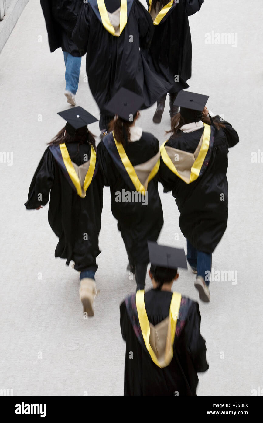 Students in graduation robes running Stock Photo Alamy