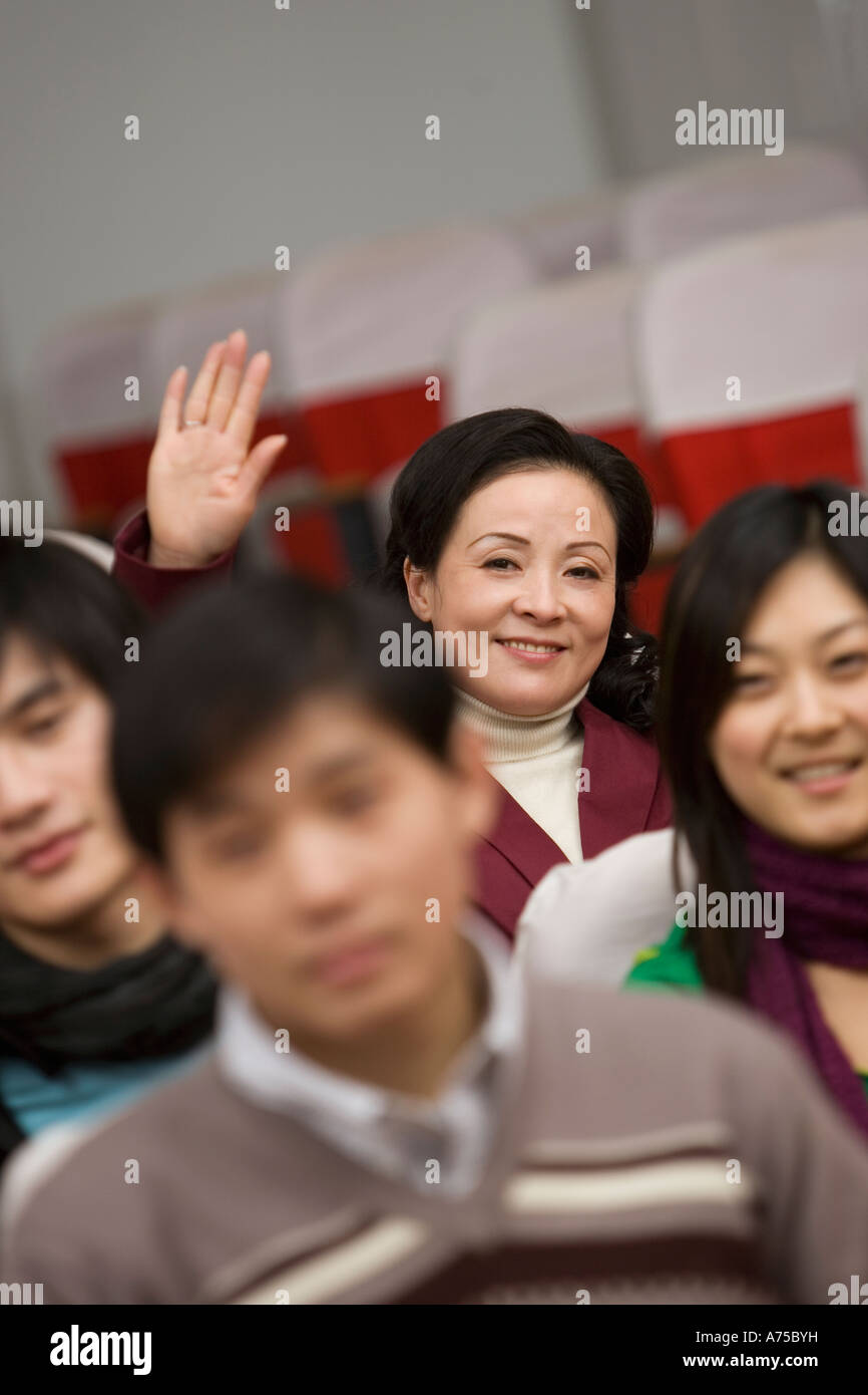 College student raising her hand in class Stock Photo