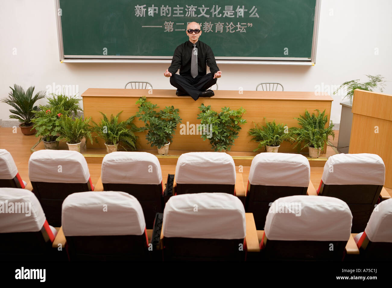 Teacher meditating on desk Stock Photo