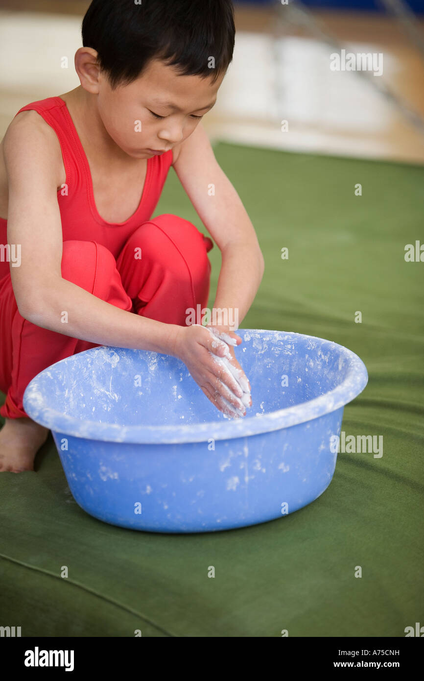 Young boy rubbing chalk on his hands Stock Photo Alamy