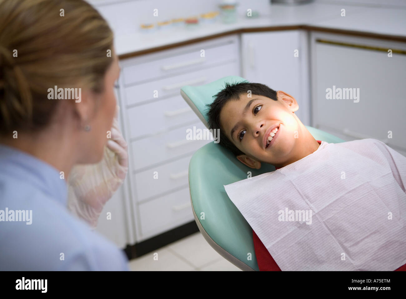 Dentist talking to young patient Stock Photo - Alamy