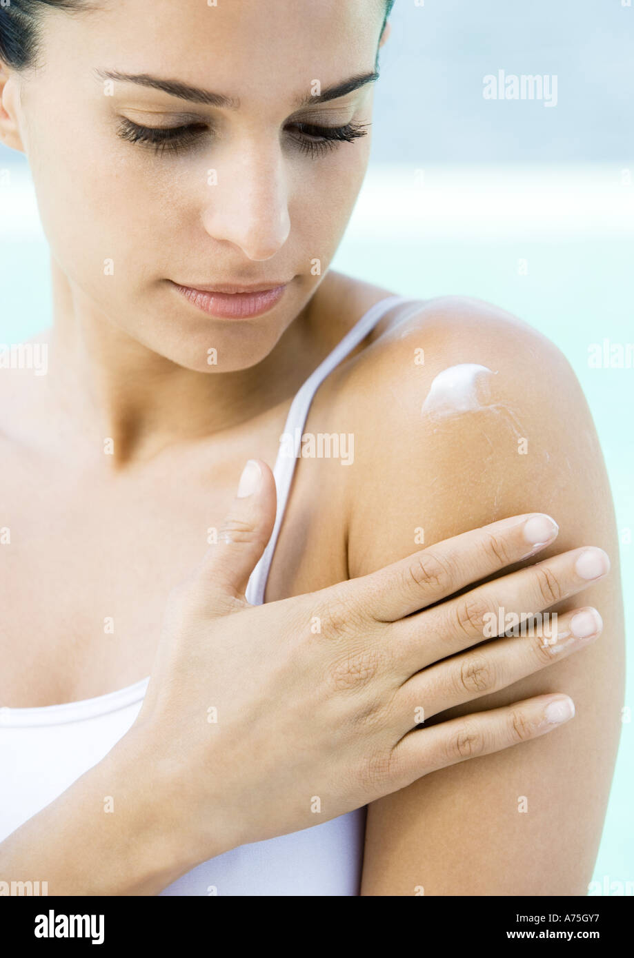 Woman applying moisturizer to shoulder Stock Photo Alamy