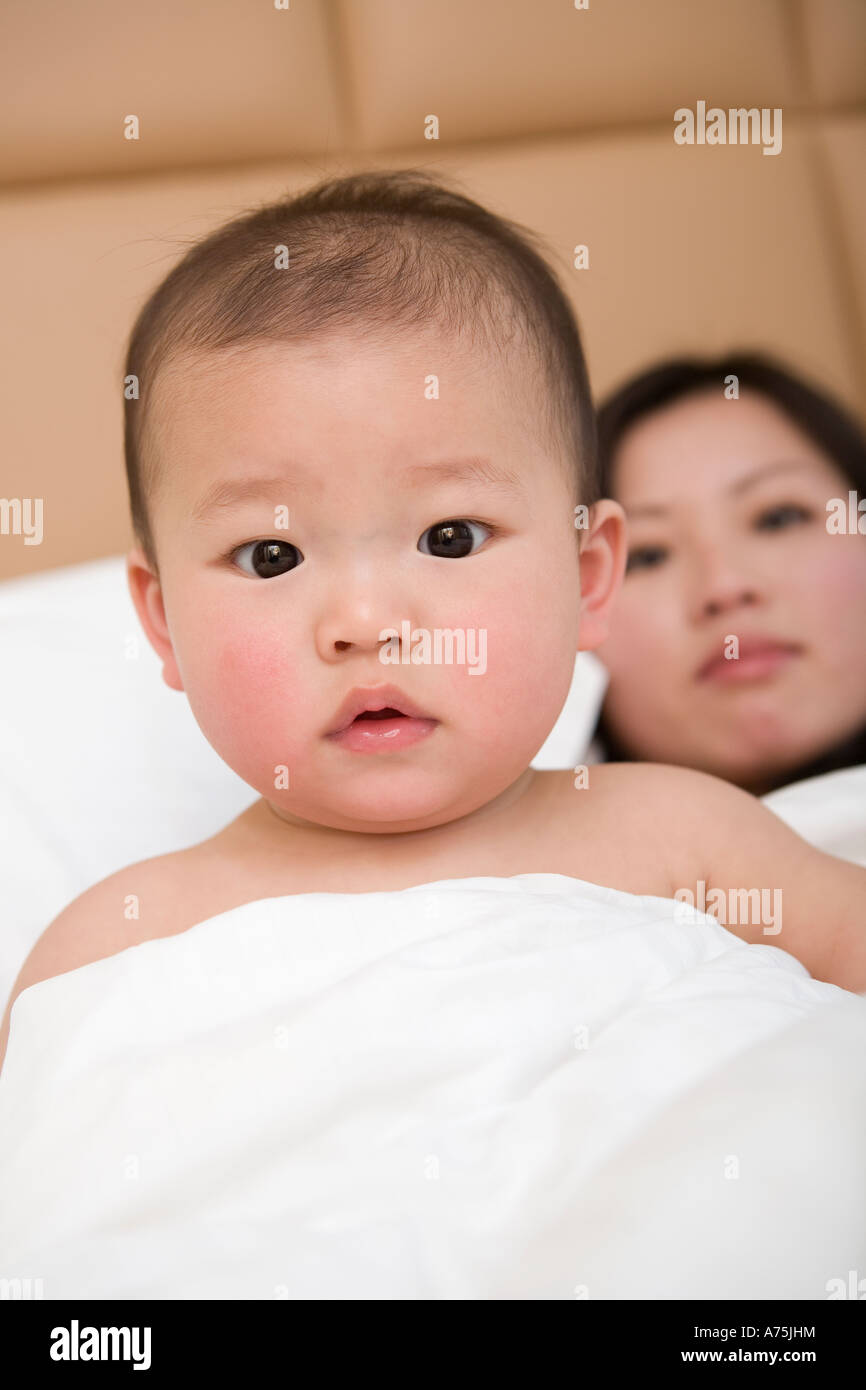 Baby sitting up in bed Stock Photo Alamy