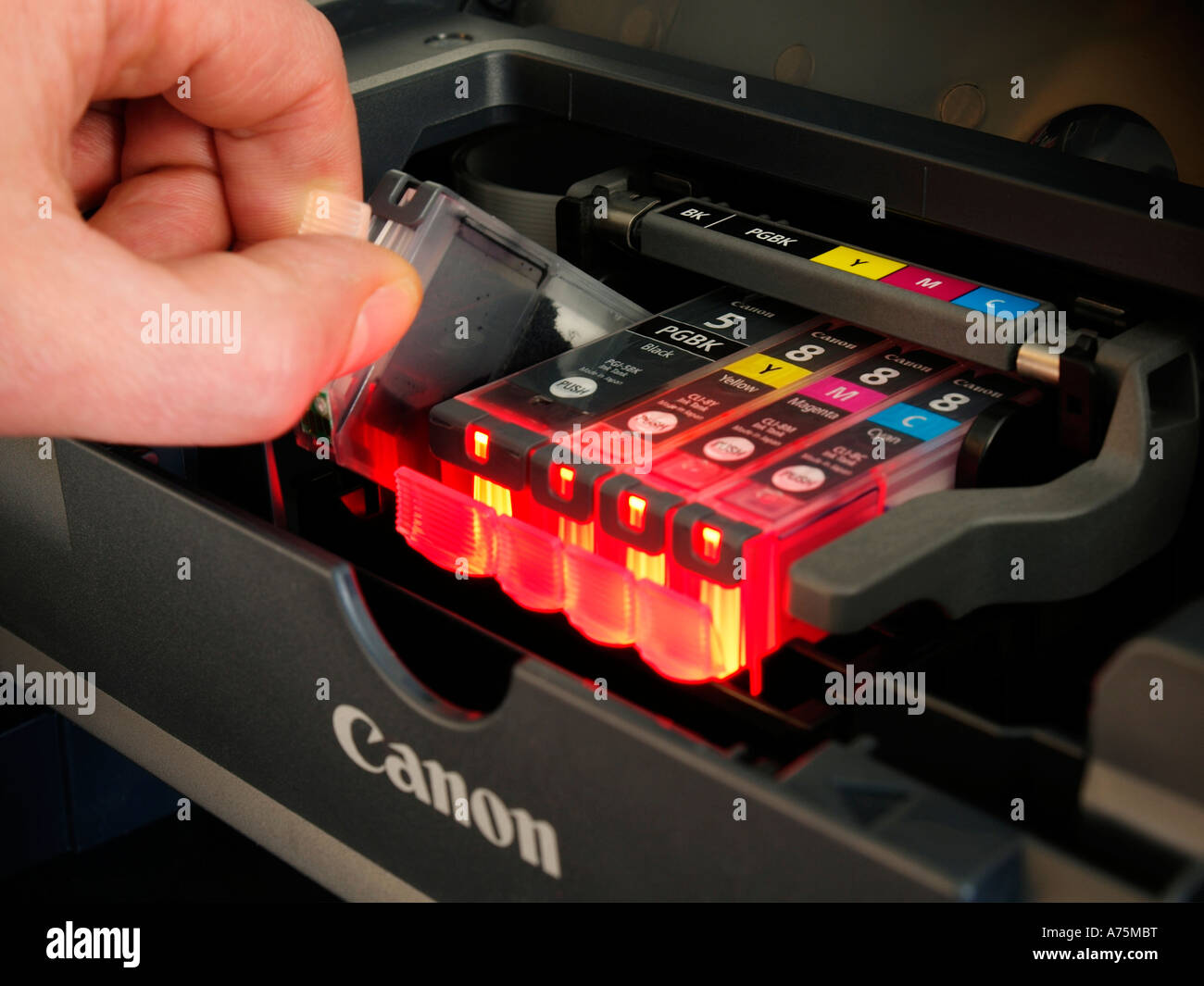 Exchanging replacing an empty used ink cartridge tank in a Canon brand inkjet printer ip4300 Stock Photo