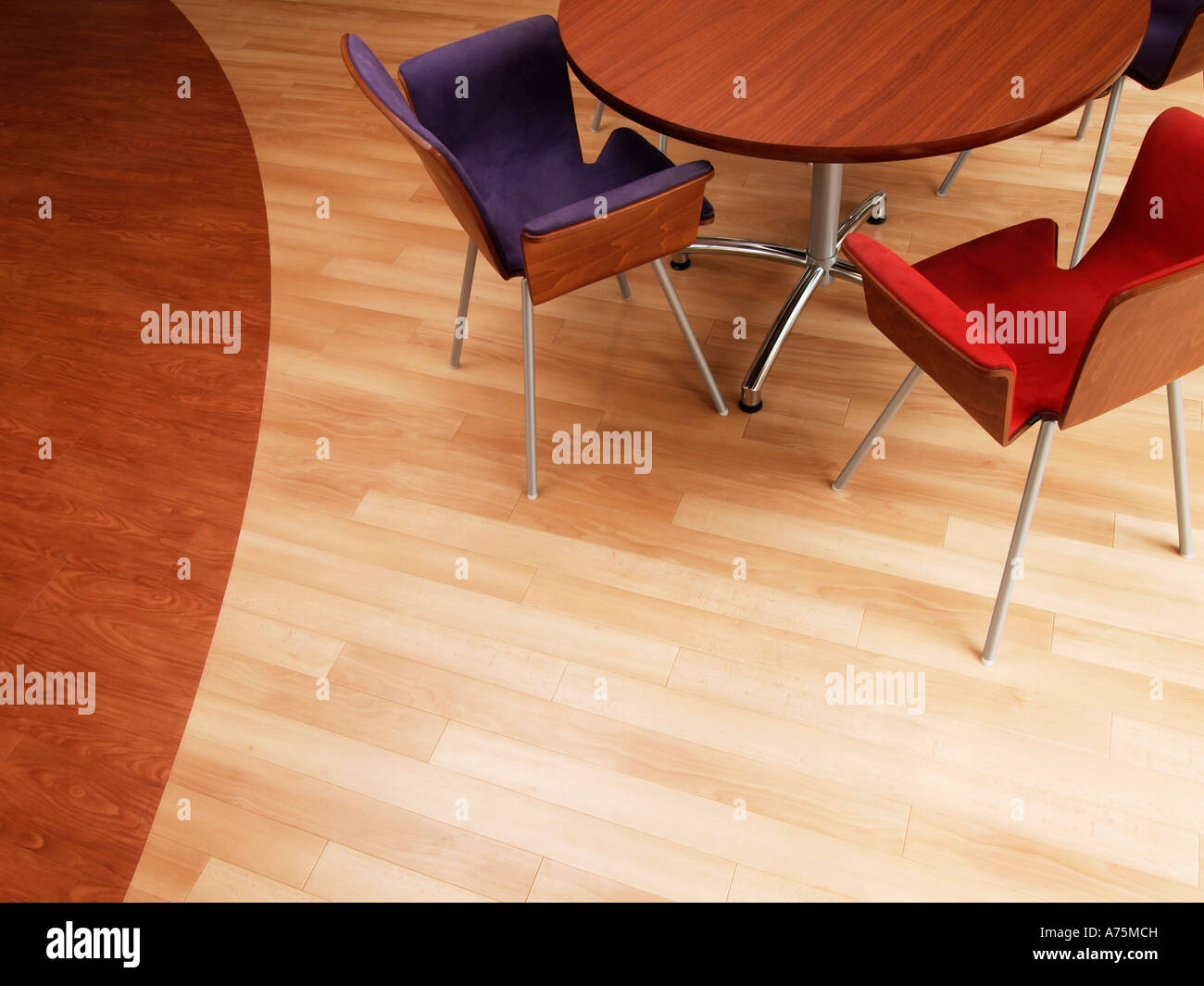 Birds eye view of round wooden table with modern design chairs on parquet floor made of two kinds of wood Stock Photo