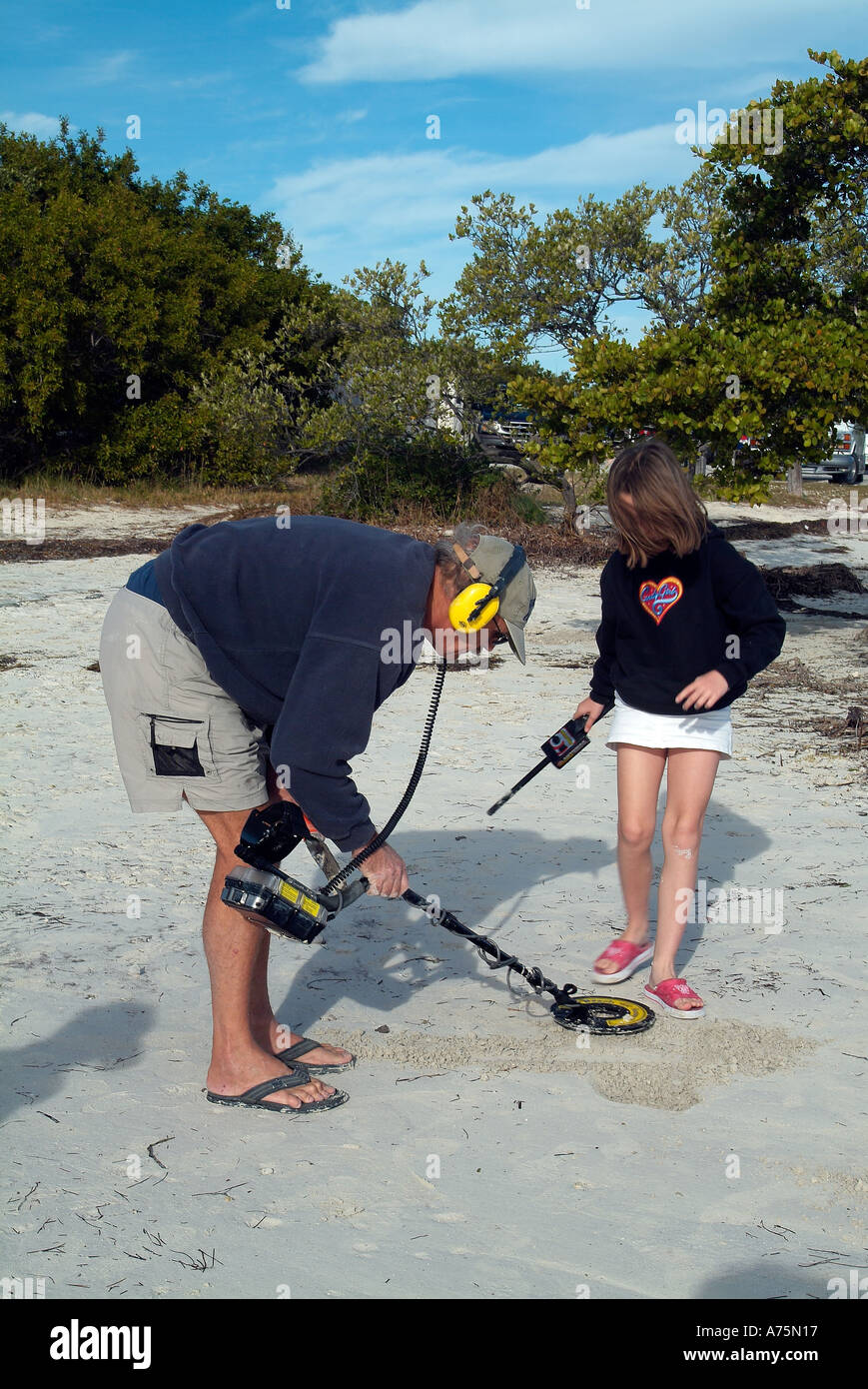 Treasure hunters with their metal detector on a beach Stock Photo Alamy