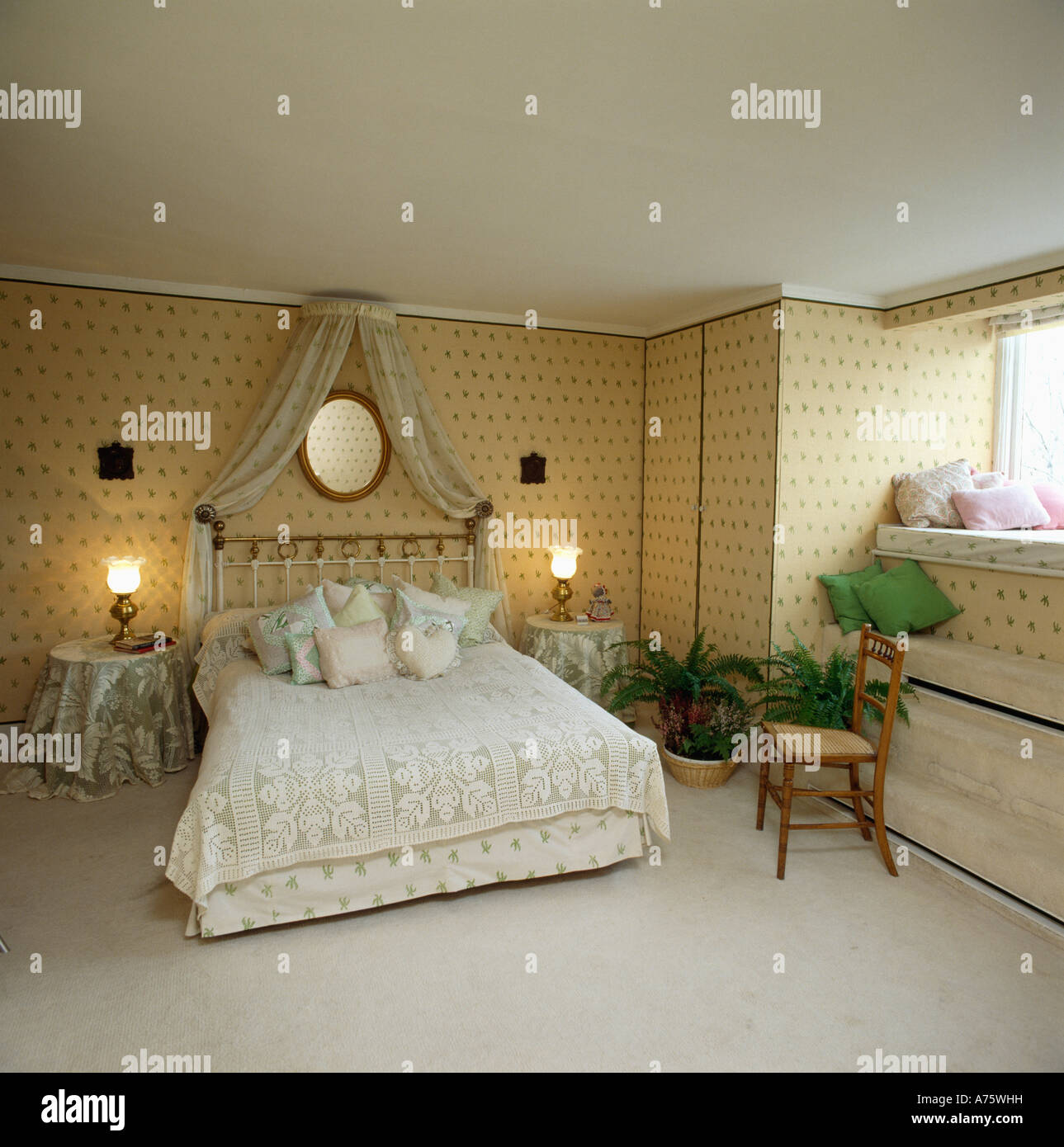 drapes above bed with lace bedlinen in bedroom with wallpaper and lighted lamps beside