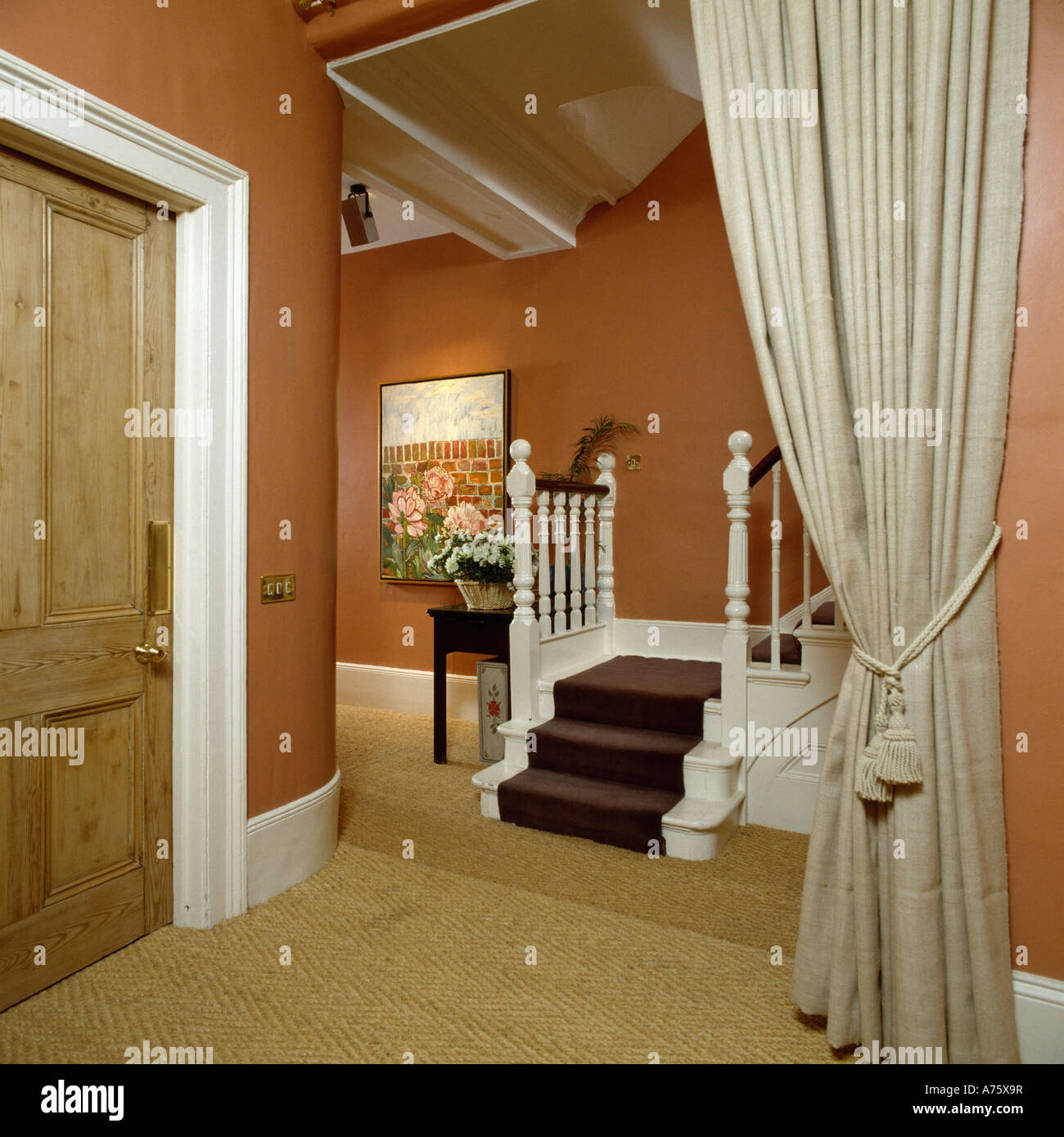Terracotta hall with sisal carpet and cream drapes Stock Photo - Alamy