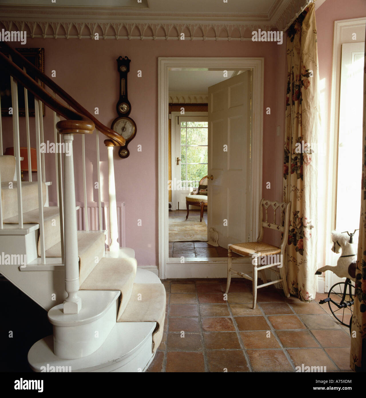 Terracotta tiled floor in pink hall with white staircase and antique ...