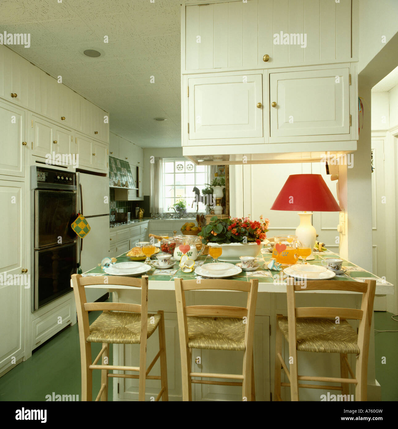 Chairs with rush seats and table in dining area in white town kitchen