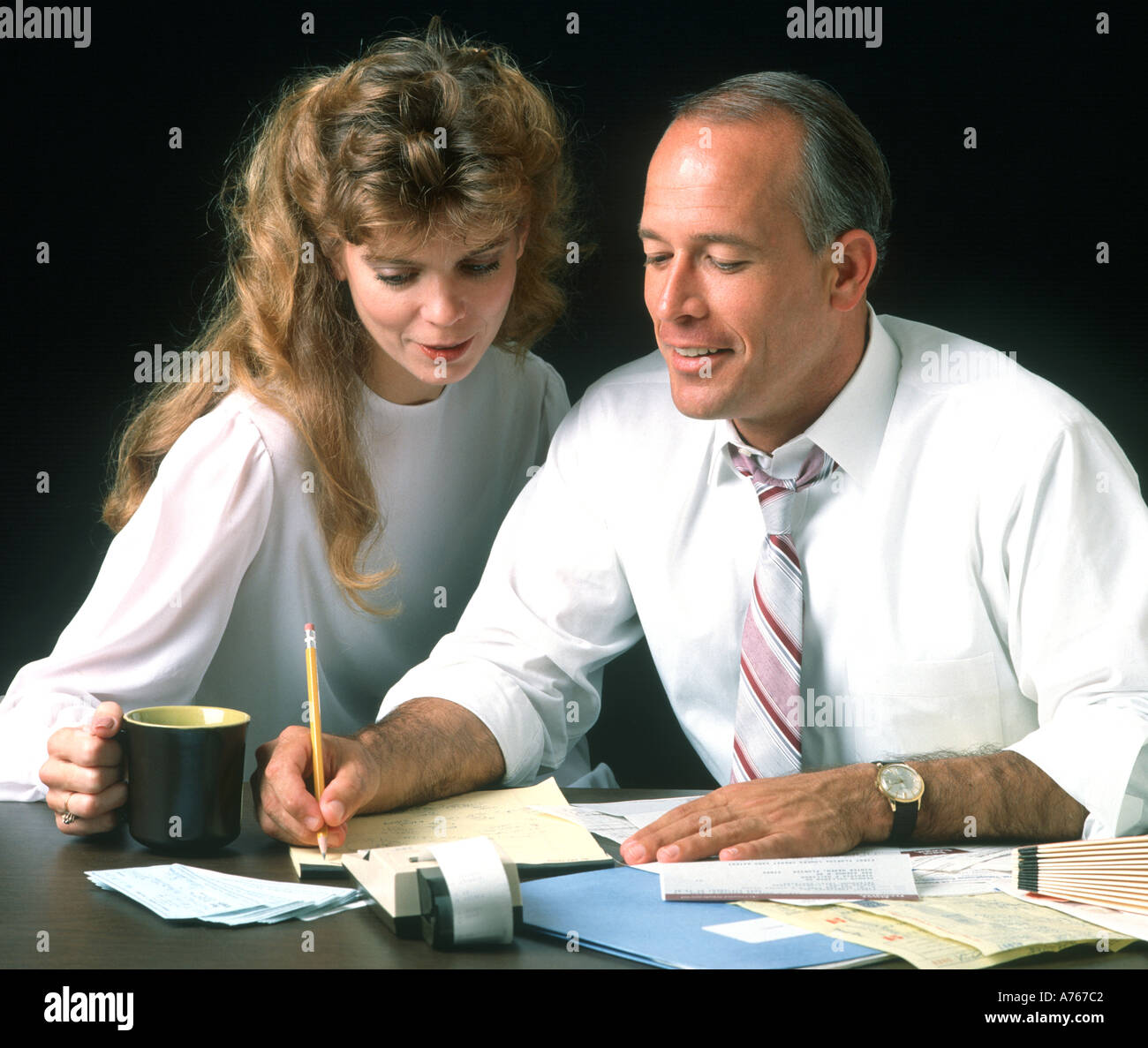 married couple paying bills at breakfast table Stock Photo