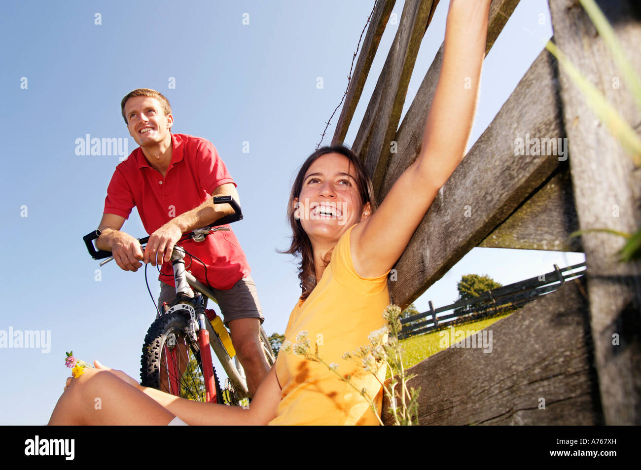 Resting On Railing Couple having a rest, woman leaning on wooden railing Stock Photo - Alamy