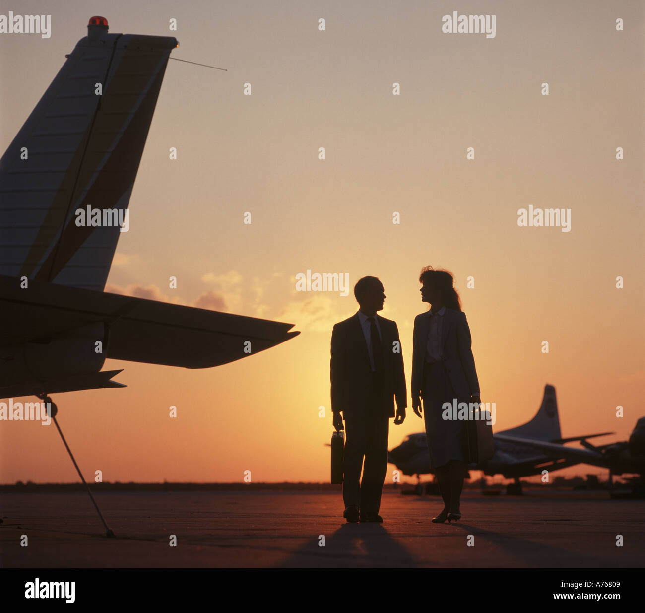 business couple preparing to board an executive jet at sunset Stock Photo